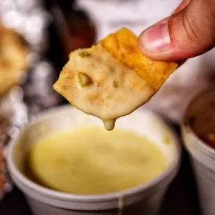 a hand dipping a cracker