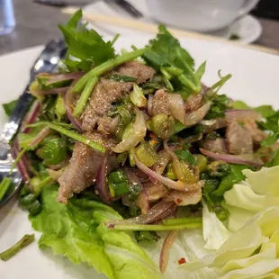 a white plate with a salad and a fork