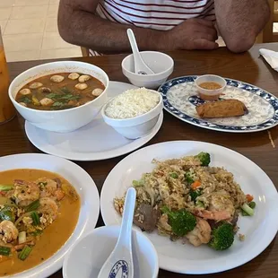 a man sitting at a table with plates of food
