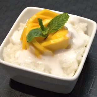 a bowl of rice pudding topped with mango slices