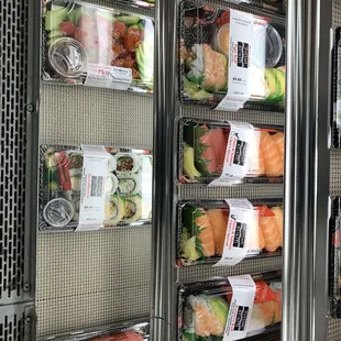 a variety of sushi in plastic containers