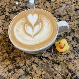 a cup of latte art with a rubber duck