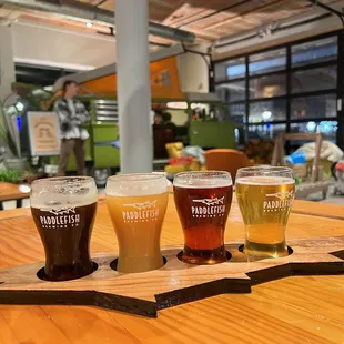 a flight of beers on a wooden table
