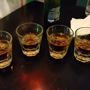 four glasses of whiskey on a table