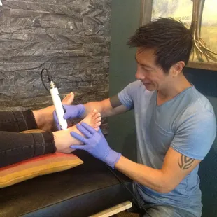 Dr Anhtuan Le using the cool light laser to speed up the body&apos;s healing process.