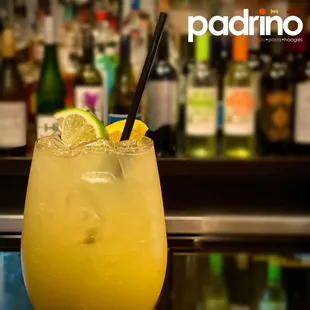 a glass of lemonade with a black straw