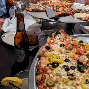 Greek pizza and vegetarian pizza. the drink is the penicillin