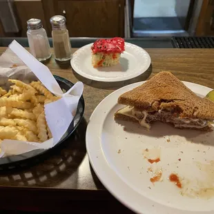 a half eaten sandwich and macaroni and cheese fries