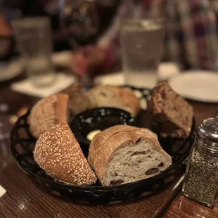 Complimentary bread basket with various breads and chili olive oil for dipping