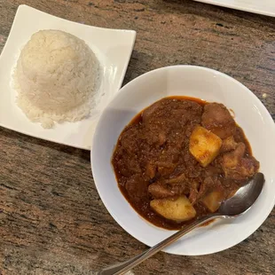 a bowl of stew and a plate of rice