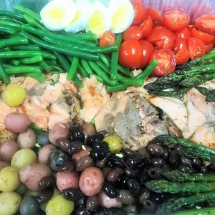 Salmon nicoise salad with baby potatoes, french green beans, assorted olives, grilled salmon, tomatoes, eggs, with light citrus vinaigrette.