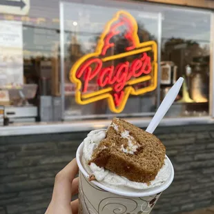 a hand holding a cup of ice cream