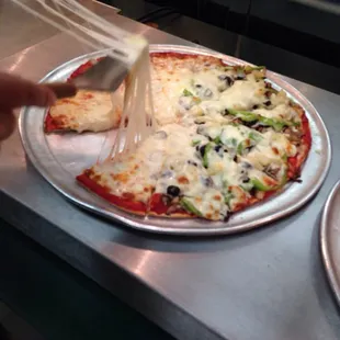 a pizza being sliced