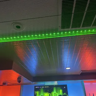 a bar with a television and neon lights