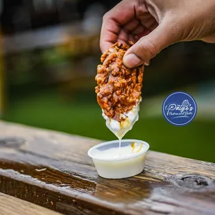 a person dipping something into a bowl