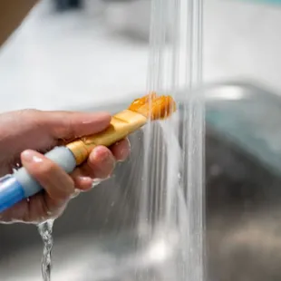 a person holding a toothbrush in a sink