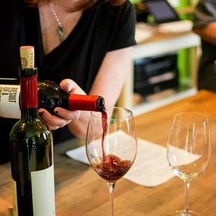 a woman pouring a glass of wine