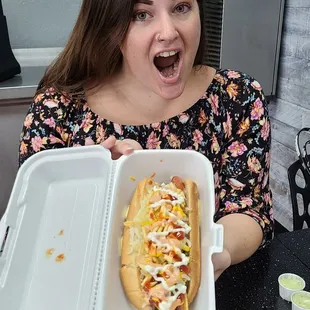a woman holding a hot dog