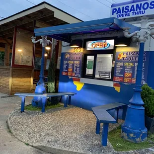 a blue bench in front of a restaurant