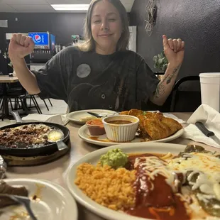 a woman sitting at a table with plates of food