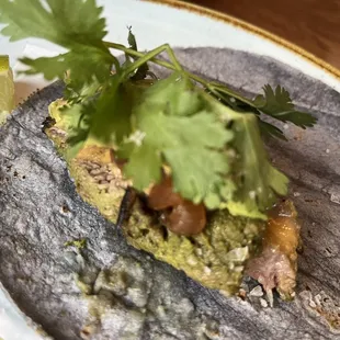 a tortilla on a plate with a slice of lime