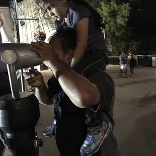 a man holding a child on his shoulders