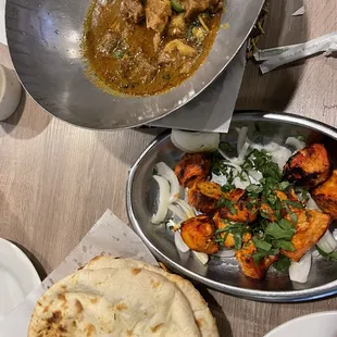 Goat karahi (top), chicken boti (middle), naan (bottom)