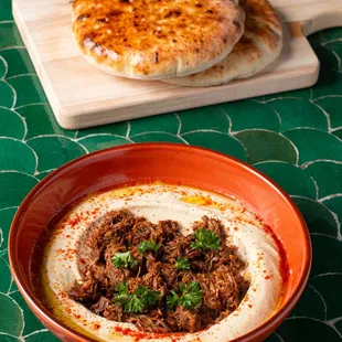 a bowl of hummus and pita bread