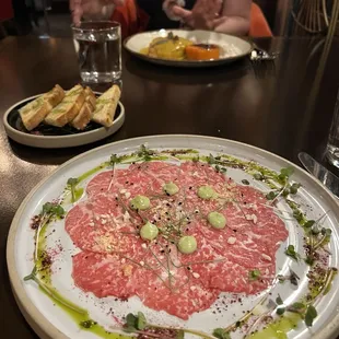 a woman sitting at a table with plates of food