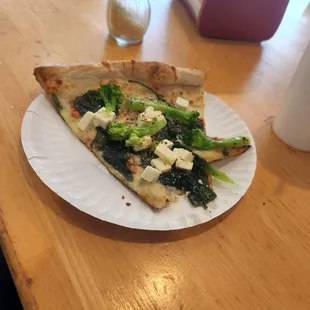 a slice of pizza on a paper plate