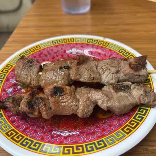a plate of beef skewers