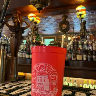 a red cup sitting on a bar
