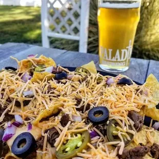 a plate of nachos and a glass of beer