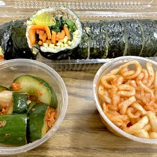 a sushi roll, pasta, and cucumbers