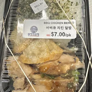 a plastic container of chicken and rice