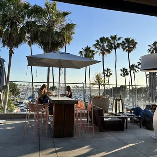 a group of people sitting at a table under an umbrella
