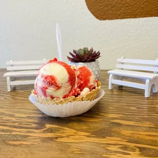two scoops of ice cream in a paper bowl