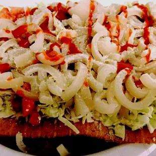 prepared chicharron with pickled pork skin, mayonnaise,cabbage,cheese,tomato, valentine sauce and chamoy.