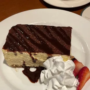 a piece of cake with whipped cream and strawberries