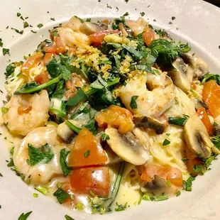 a plate of pasta with shrimp and vegetables