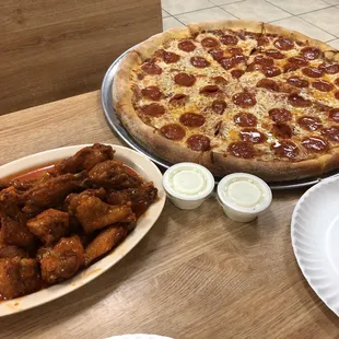 a pizza with pepperoni and chicken wings