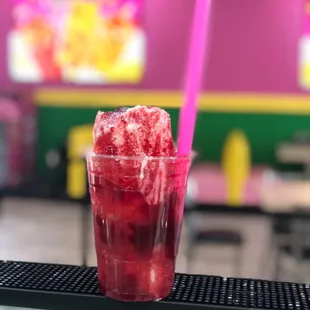 a glass of ice cream with a pink straw