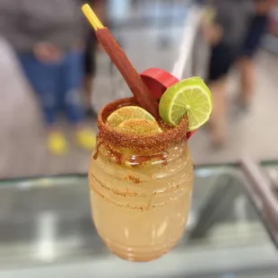 a close up of a drink with a straw and lime garnish