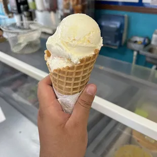 a hand holding an ice cream cone