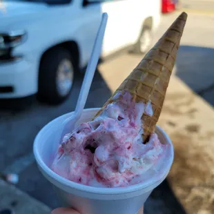 a hand holding a cone of ice cream