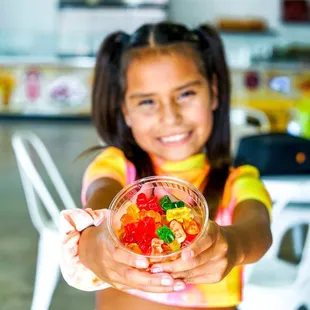 a girl holding a bowl of gummy bears