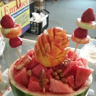 Watermelon filled with fruit, and peanuts and topped with lime juice and chamoy. Sandia loca