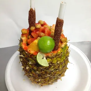 Our infamous &quot;Pina-Loka&quot;, it is a hollowed out pineapple filled with pineapple, apple, japanese peanuts, chamoy, lime and Tajin chile powder