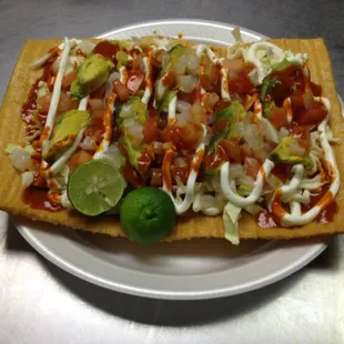 A fresh &quot;Chilindrina&quot; with cabbage, tomato, avocado,pickled pork skin, sour cream, valentina and lime.