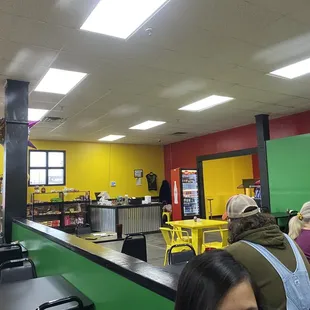 people sitting at tables in a brightly colored cafeteria